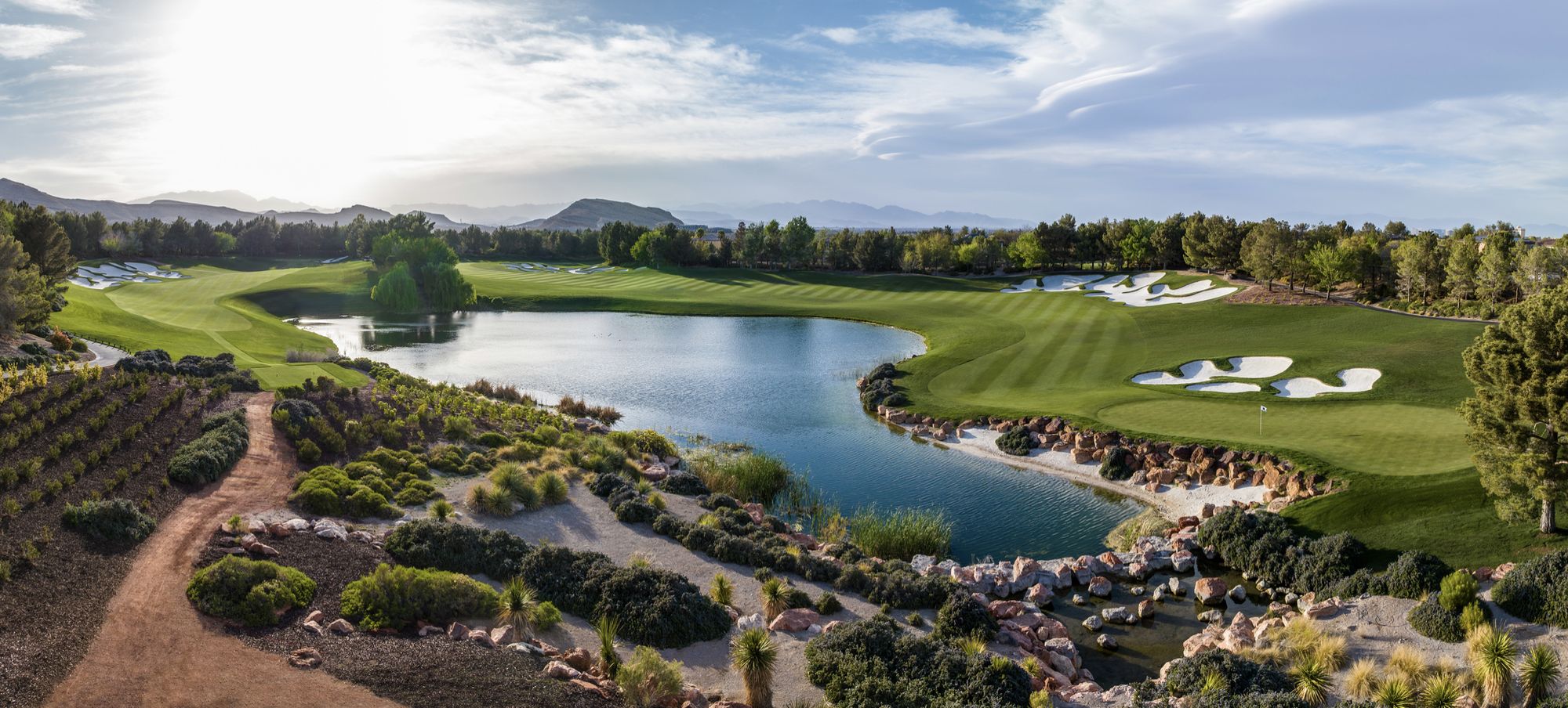 A green with the Southern Highlands crest flag, bunkering and the clubhouse beyond at golden hour